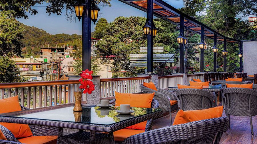 coffee shoA rooftop dining area with scenic mountain views, decorated with stylish chairs and tables - Vinsober Monal, Nainital