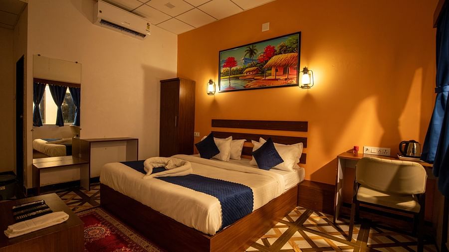 corner view image of the super deluxe room with a double bed and a painting hanging above it - VITS Select Diamond Resort, Sasan Gir