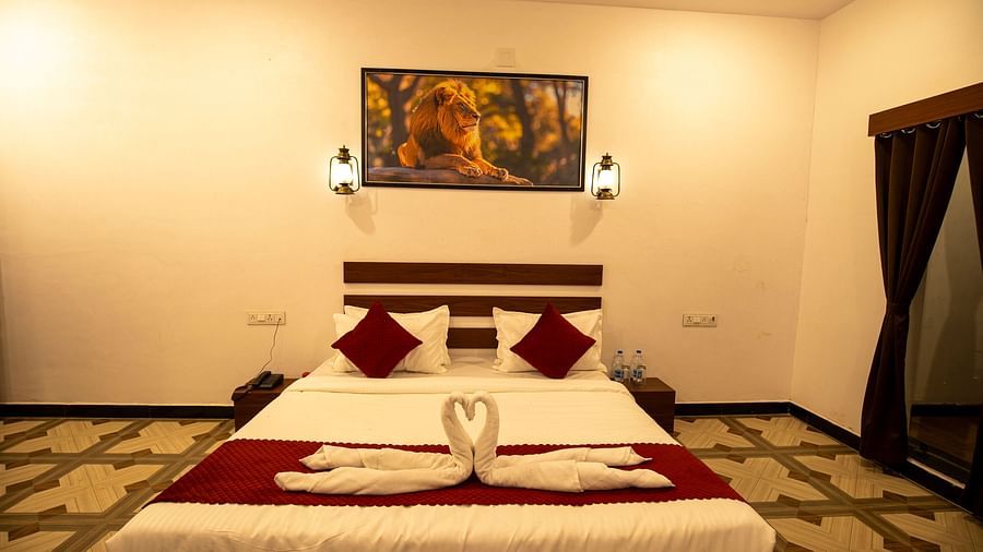 Deluxe room featuring a double bed with cushions and towel swans - VITS Select Diamond Resort, Sasan Gir 