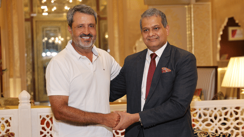 Guest and hotel manager shaking hands in a luxurious lobby, showcasing a warm welcome.