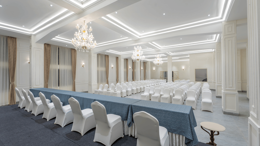 A hall with rows of covered chairs and long tables arranged in a meeting setup at Summit Norbu Ghang - The Signature Collection, Gangtok.