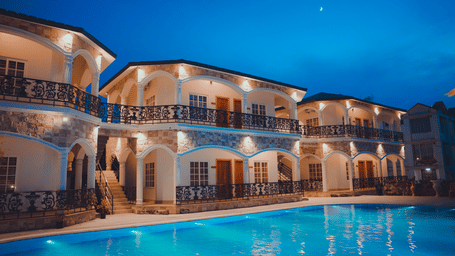 Facade of Dip Holidays, our resort in Bolpur, Santiniketan, in the late evening with a beautiful view of the swimming pool in the foreground.