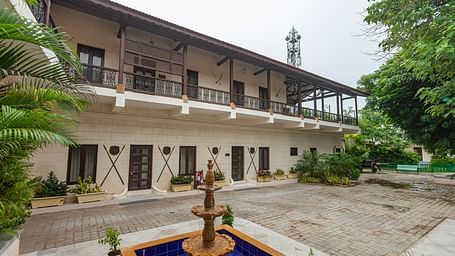Facade of Darbargadh Dared featuring the two-storey building and a fountain in front of it under clear sky