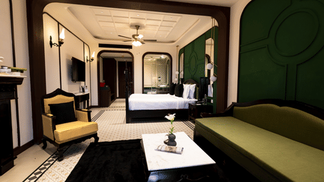 The Sohra Family Suite at Polo Resort Cherrapunji featuring a plush bed, elegant seating area, tiled flooring, and a ceiling fan.