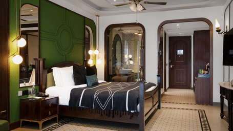 Waterfall Deck Suite at Polo Resort Cherrapunji with green-paneled bedhead, four-poster bed, arched mirror, vanity and patterned tile floor.