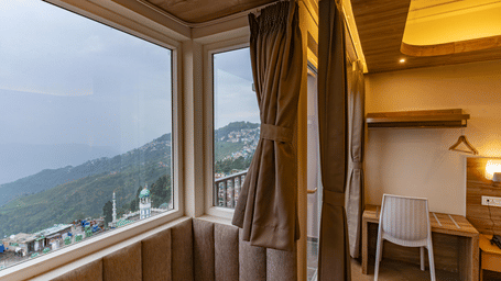 image of the premium room with a huge window exposing serene mountain views at The Soma Hotel by Avianna Group, Darjeeling