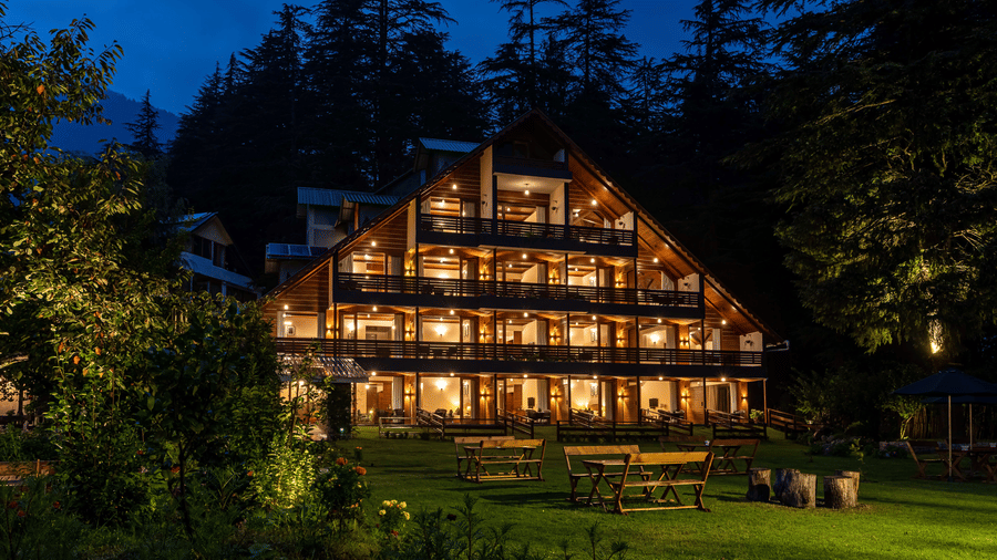 An image of a well lit facade of Bedzzz Xclusiv Baikunth, Manali at during the night time