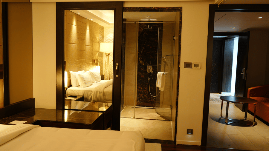 A view of the room featuring a bed and a separate living area with a sofa and table at Cenneys Gateway - Pride of Salem.