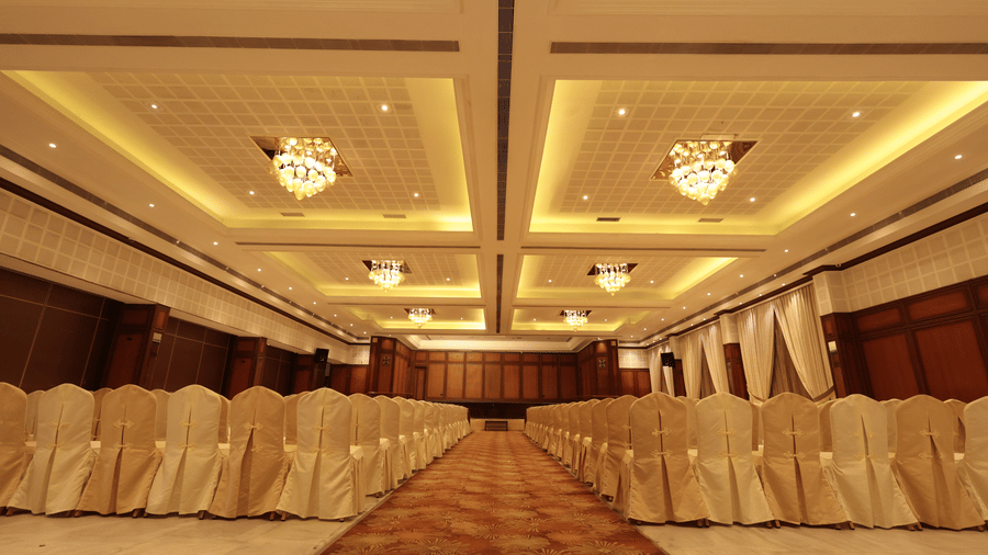 A front view of a banquet hall with chairs arranged on both sides with yellow lighting | Cenneys Gateway - Pride of Salem.