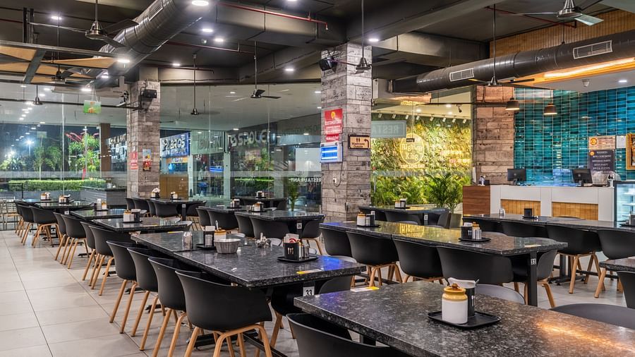 Cosy dining space with black tables and natural lighting at Hotel Highway King, Bilaspur.