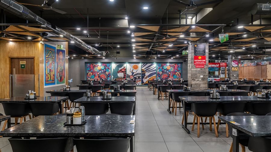 Polished black tables and red-accented wall artwork inside Hotel Highway King, Bilaspur.