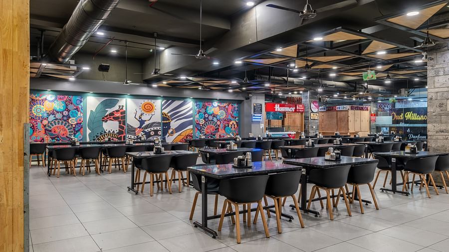 Stylish restaurant section with abstract wall art and contemporary dining setup at Hotel Highway King, Bilaspur.