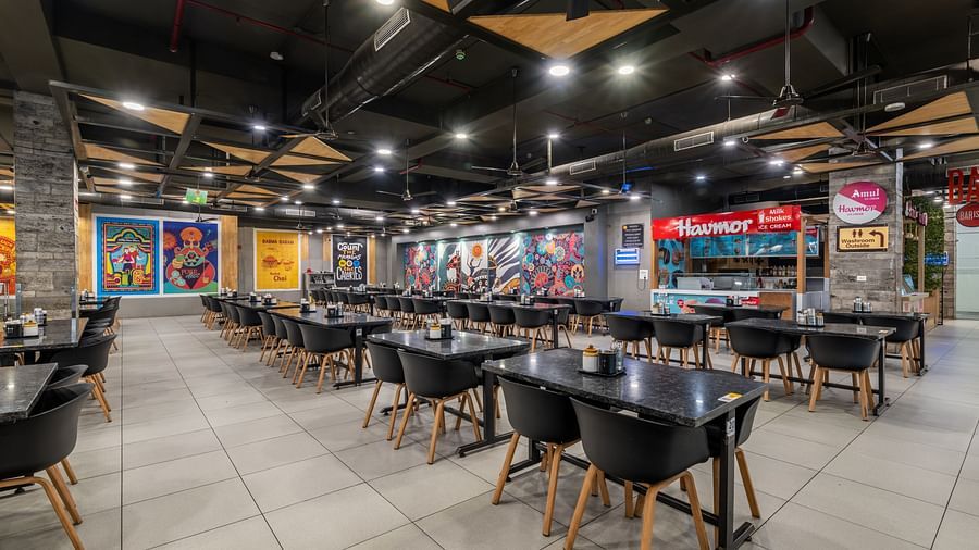 Expansive dining hall with creative murals and ample seating at Hotel Highway King, Bilaspur.
