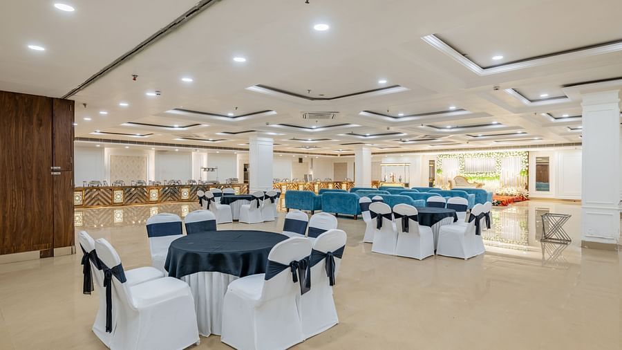 Event space with cluster seating arrangement and navy bows tied around at Hotel Highway King, Bilaspur.