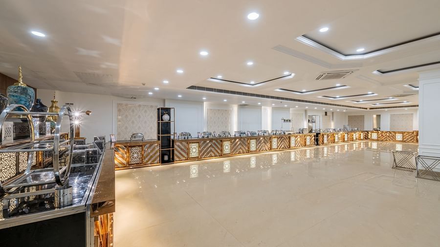 Well-lit event hall with buffet counter setup at Hotel Highway King, Bilaspur.