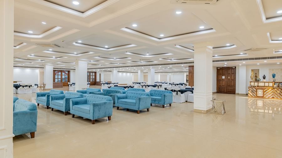 Banquet space featuring multiple blue sofa sets arranged in a modern layout at Hotel Highway King, Bilaspur.