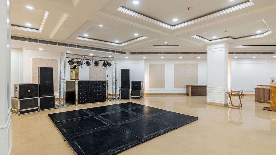 Banquet hall with a stage and audio-visual setup ready for events at Hotel Highway King, Bilaspur.