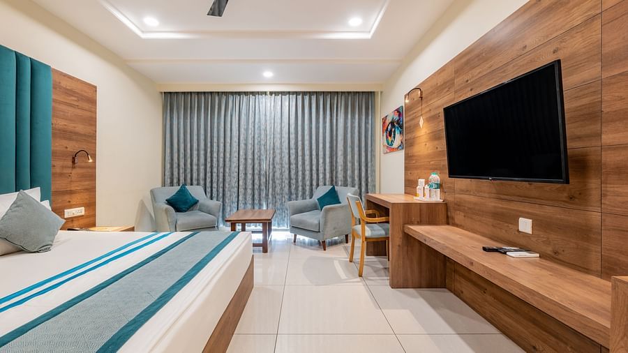 King size Bed Room with a flat-screen TV, work desk, and lounge area at Hotel Highway King, Bilaspur.