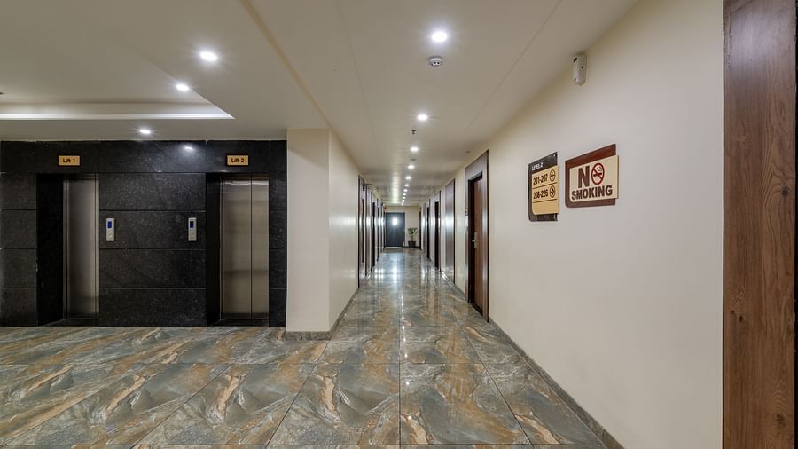 Hotel corridor with polished flooring, ambient lighting, and framed artwork at Hotel Highway King, Bilaspur.
