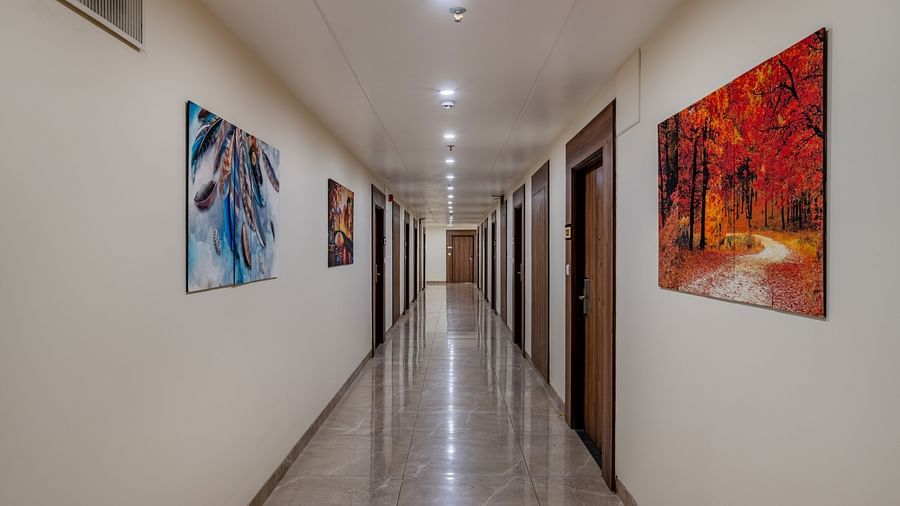 Well-lit hallway featuring wall art and marble flooring at Hotel Highway King, Bilaspur.