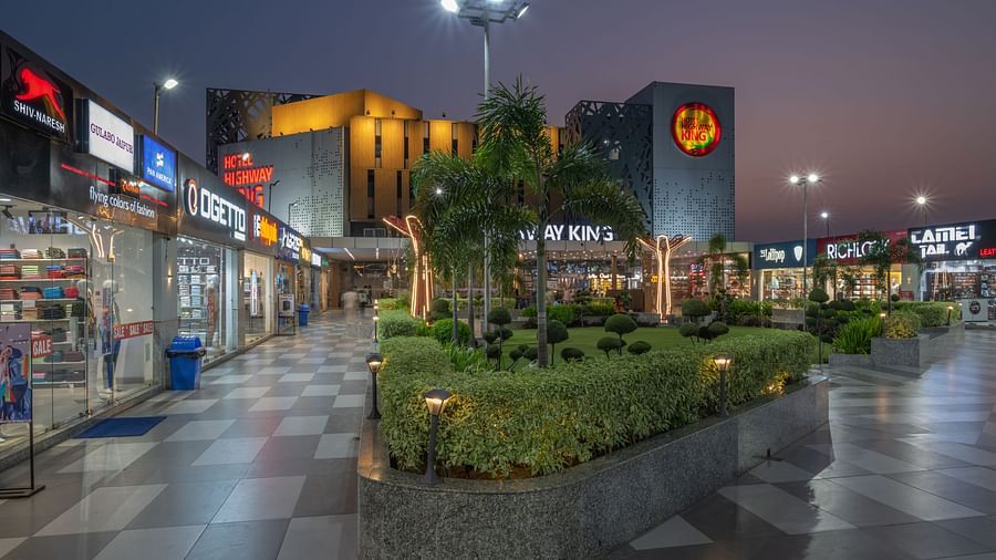 Retail and garden area near the hotel entrance with evening lights at Hotel Highway King, Bilaspur.