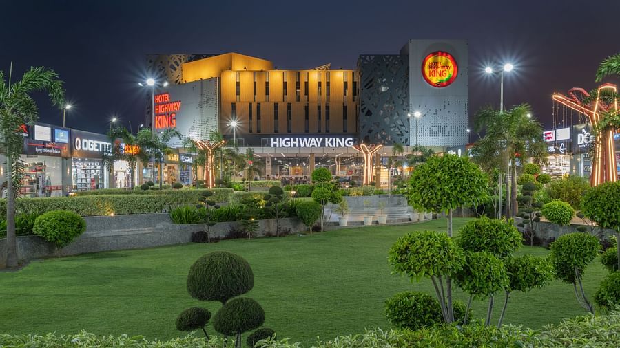 Night view of the well-lit exterior and gardens at Hotel Highway King, Bilaspur.