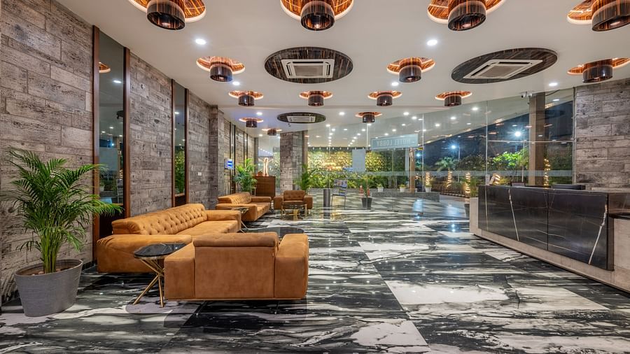 Hotel lobby with modern ceiling lights, leather sofas, and marble flooring at Hotel Highway King, Bilaspur.