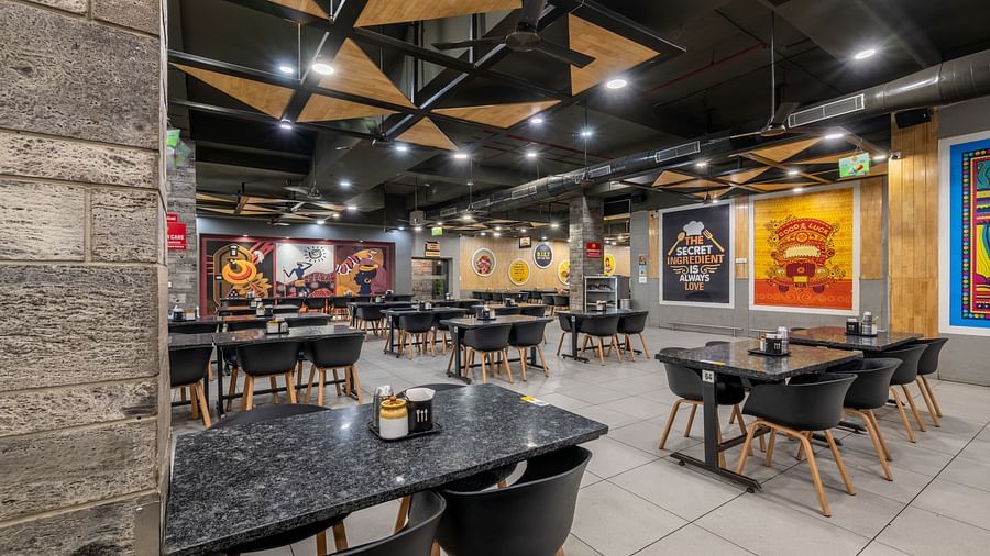 Wide interior shot showcasing modern ceiling design and ample seating at Hotel Highway King, Bilaspur.