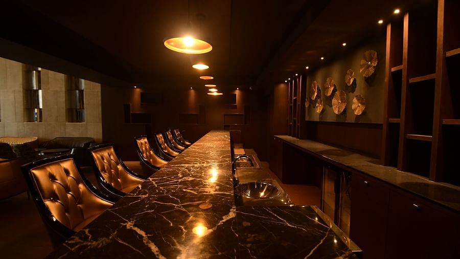 A large marble table surrounded by chairs, complemented by warm lighting