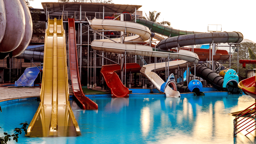 View of a large water slide structure featuring multiple closed and open slides, including a prominent wide-drop slide, leading into the pool at Kumar Resort by Turtle.
