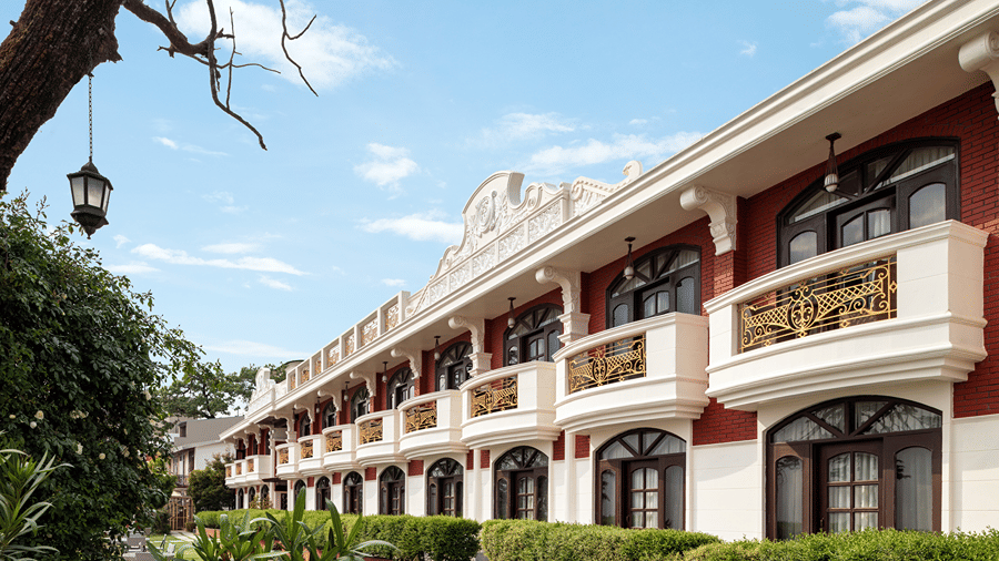 A building exterior featuring balcony railings and arched windows at Ramada by Wyndham Mussoorie Mall Road.