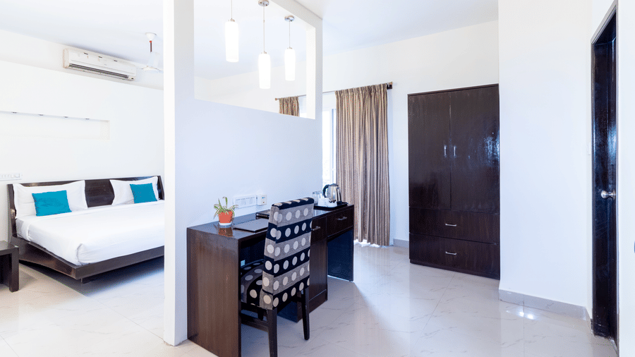 Bright suite room with double bed and wardrobe at Sanctum Suites Domlur Bangalore