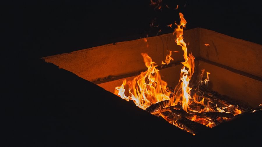 A bonfire burning in a pit at night