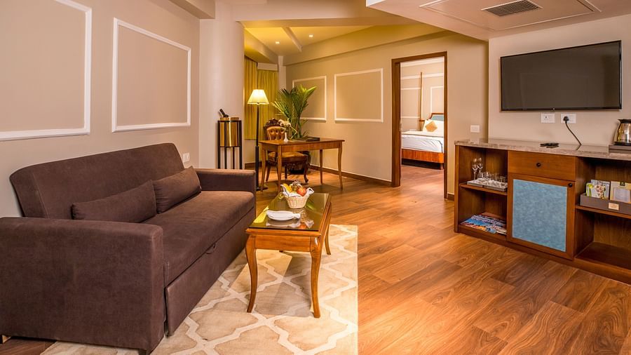 Spacious cushioned sofa with a wall-mounted television facing it on the opposite wall.