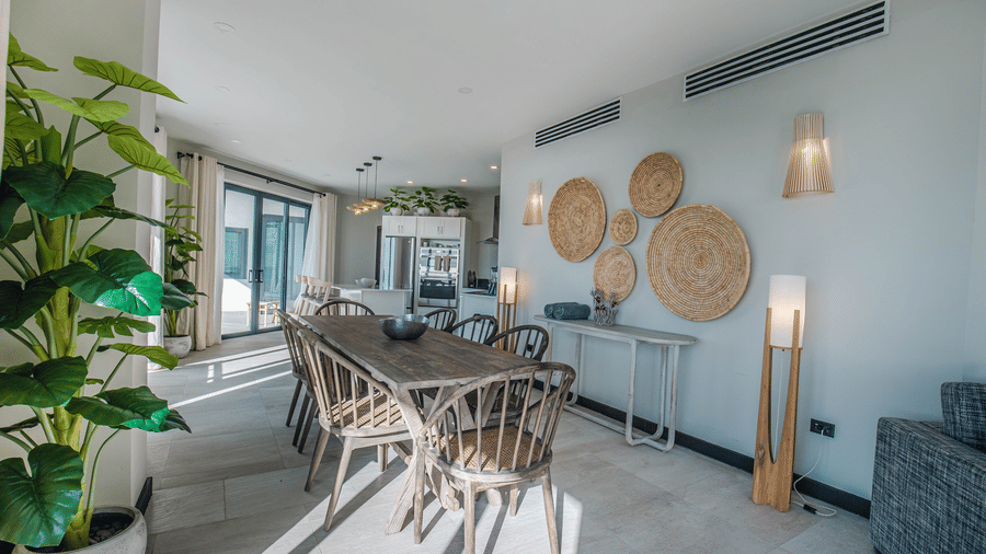 A dining space with a table, chairs, and wall art at Tamarind Hills Resort and Villas, Antigua.