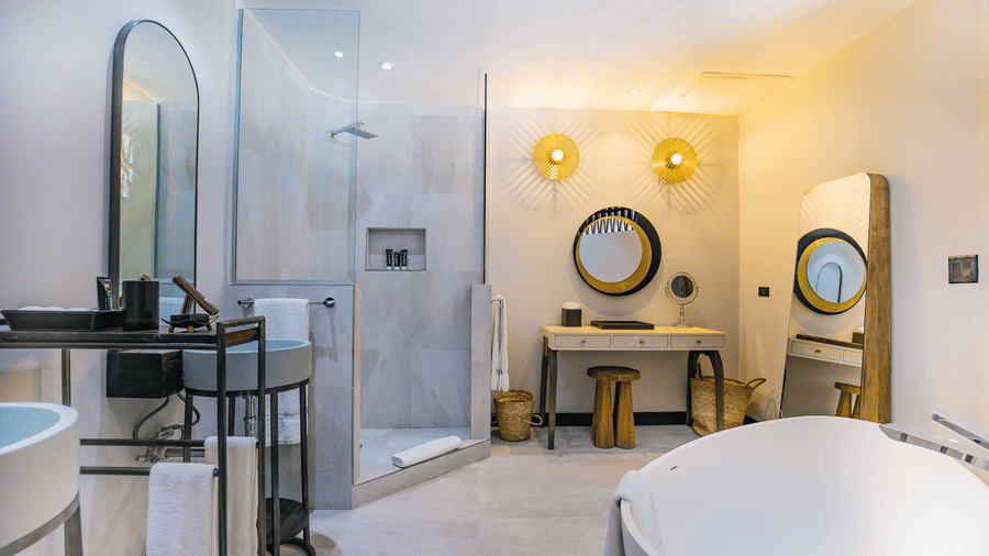 A bathroom with a sink, mirrors, a bathtub and a shower at Tamarind Hills Resort and Villas, Antigua.