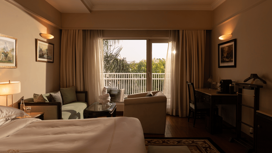 Luxury King Bed Room with Balcony at The Claridges New Delhi, featuring a plush bed and a large glass window