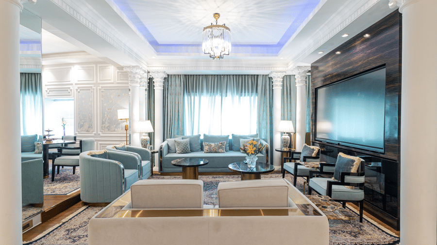 an image of the living room with ample of seating space and a wide wall mounted television at our diplomatic suite room - The Claridges New Delhi