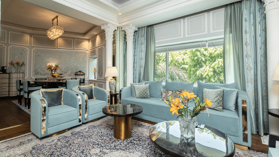 An image of the living area in our Diplomatic suite room with blue couches for comfort and elegance - The Claridges New Delhi