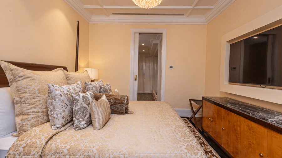 image of the bedroom with modern interiors and a door leading to the walk in closet at our lutyens luxury suite - The Claridges New Delhi