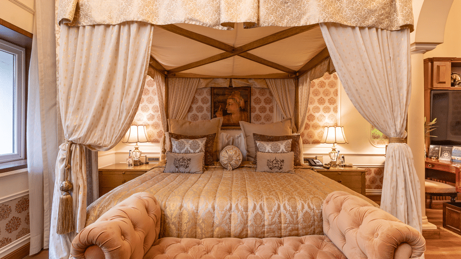 front view of the bedding of the heritage parlour suite  with a mughal style painting hung on the wall of the head board of the bed -  The Claridges New Delhi