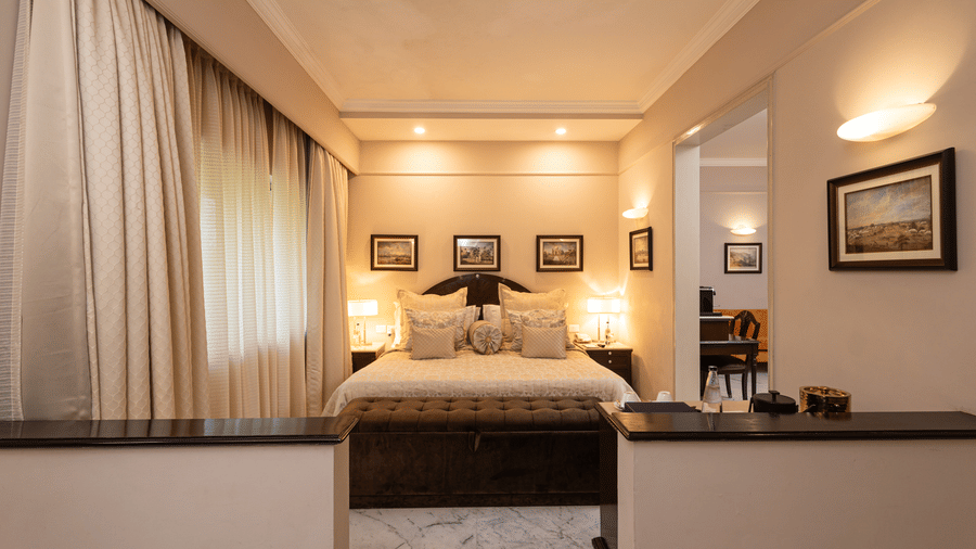 a far view of the bed with a partition towards at our heritage parlour rooms - The Claridges New Delhi