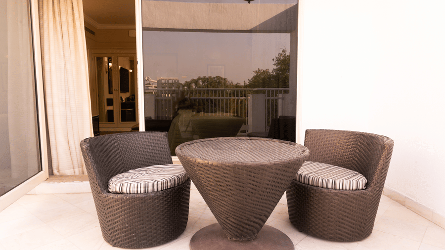 outdoor seating area with a coffee table at the heritage terrace room - The Claridges New Delhi