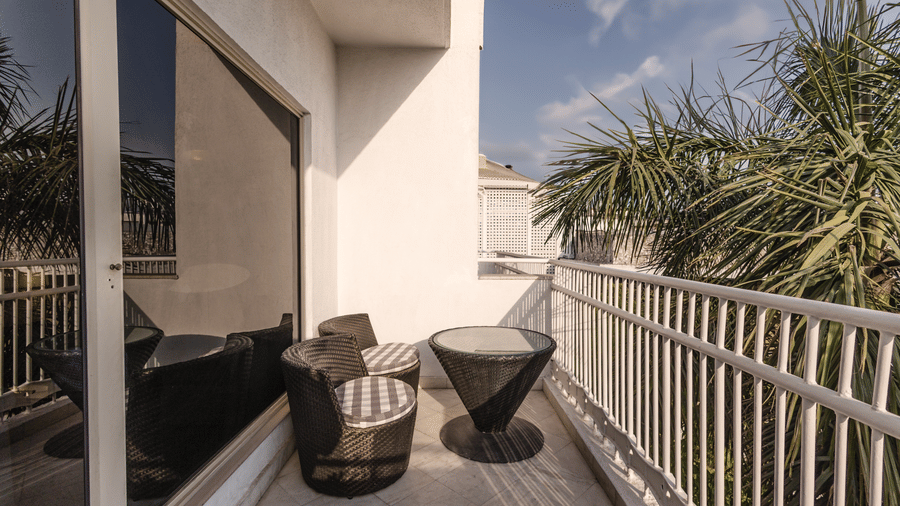 image of the balcony with a seating area and a coffee table for two guests at out heritage balcony room - The Claridges New Delhi