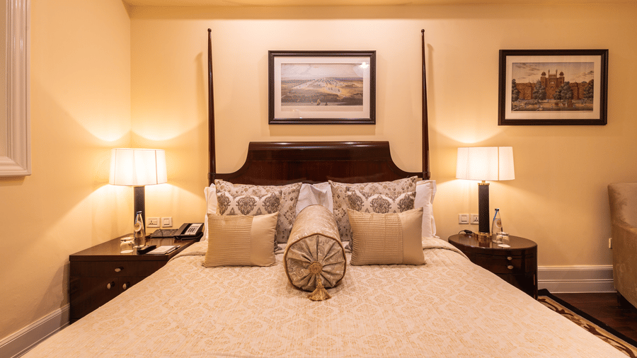 image of a king size bed with table lamps at both sides of the bed at heritage parlour rooms - The Claridges New Delhi