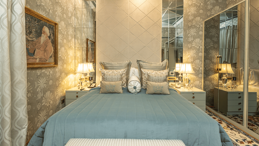 image of a king size bed with a teal blue comforter spread over the bed at our heritage luxury suite - The Claridges New Delhi