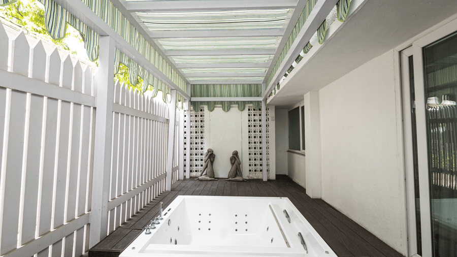 a bright image of the outdoor whirlpool with hard wood porch at our heritage luxury suite - The Claridges New Delhi