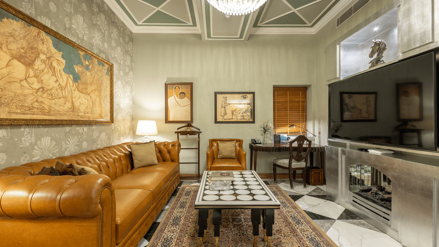 full view of the living room with huge photo frames and a comfortable elegant couch at our heritage luxury suite - The Claridges New Delhi