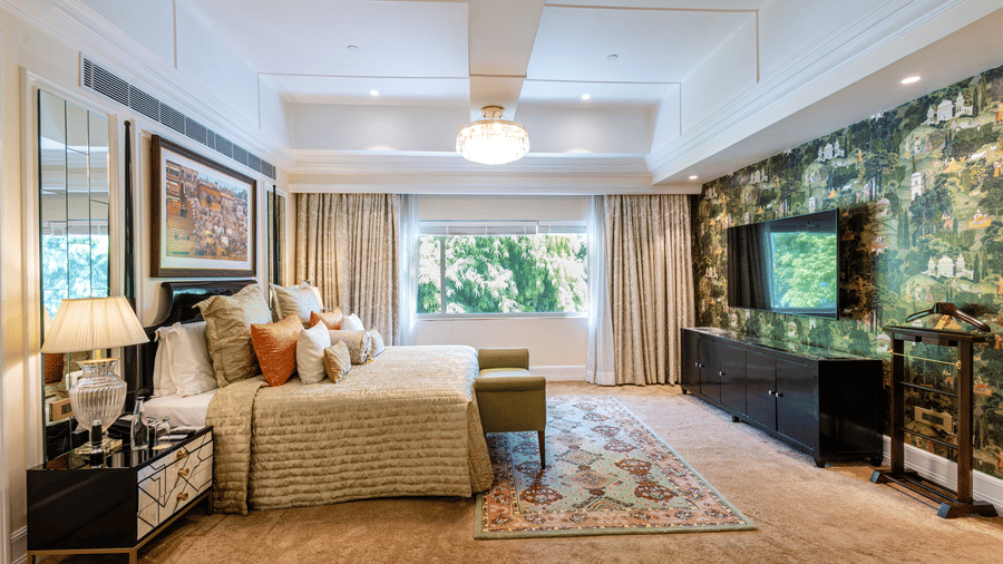 image of the willingdon crescent suite with plush bedding and a wall mounted television placed opposite to it  - The Claridges New Delhi