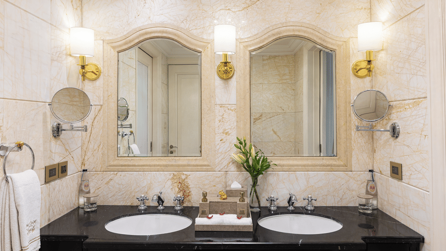 image of two washbasins with two seprate arched mirrors above them at the bathroom of our wellingdon crescent suite - The Claridges New Delhi